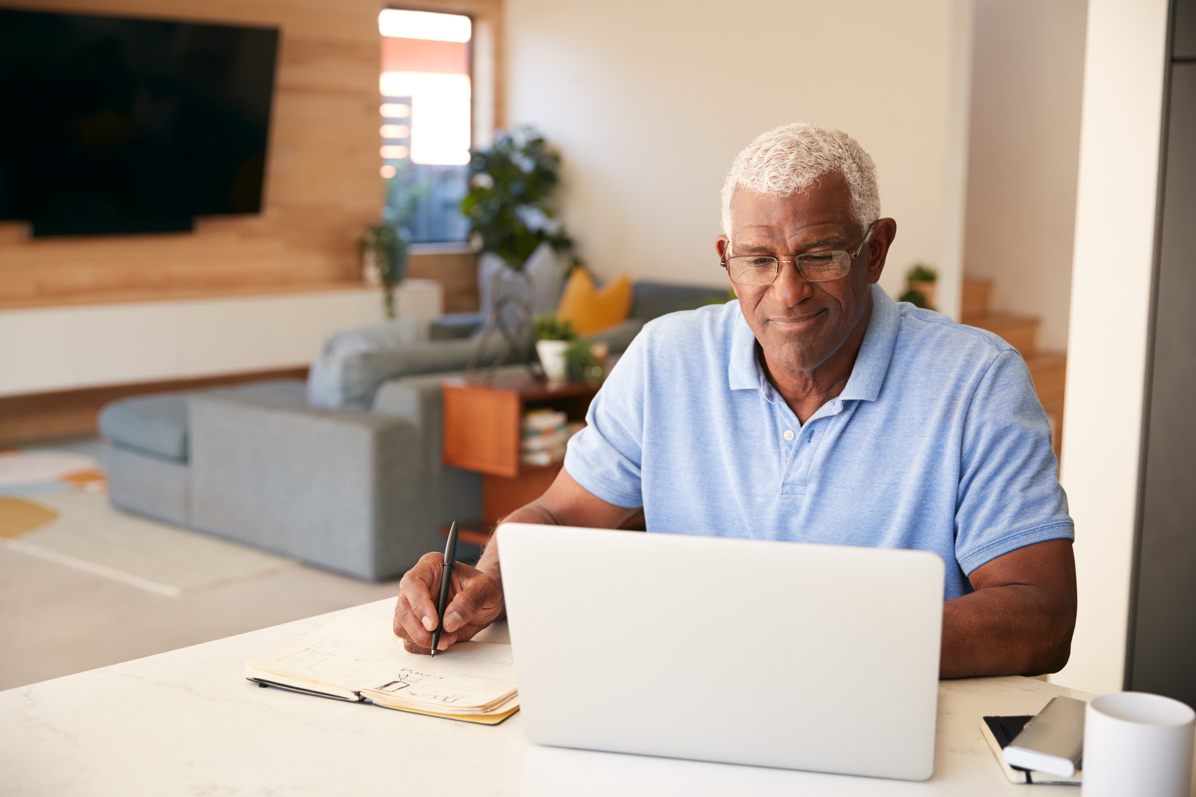 Senior African American Man Using Laptop To Check Finances At Home