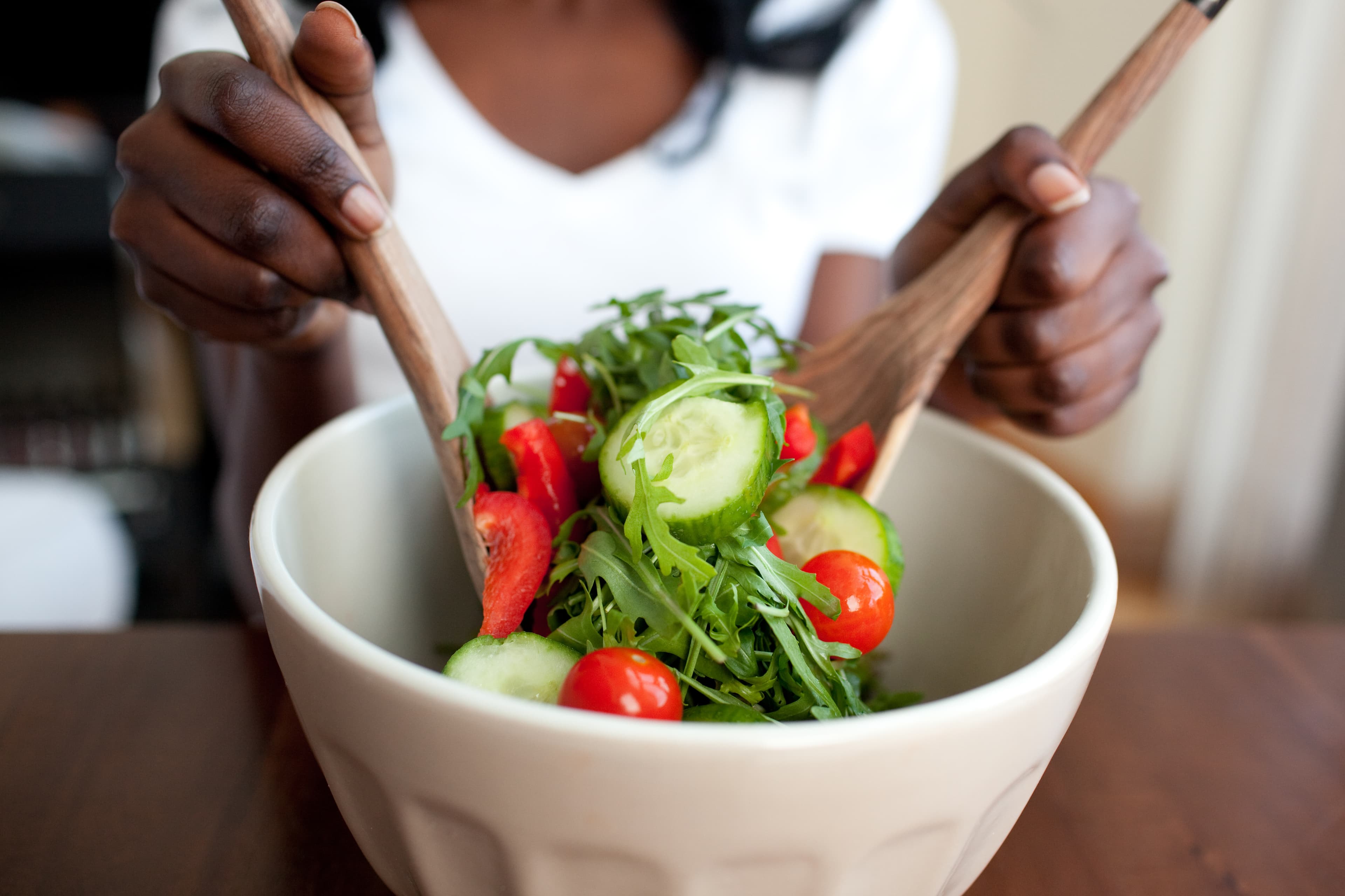 Ethnic woman preparing a salad at home