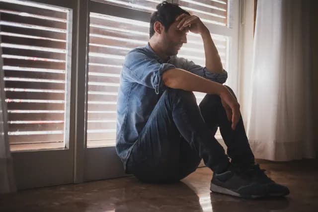 man depressed window thinking