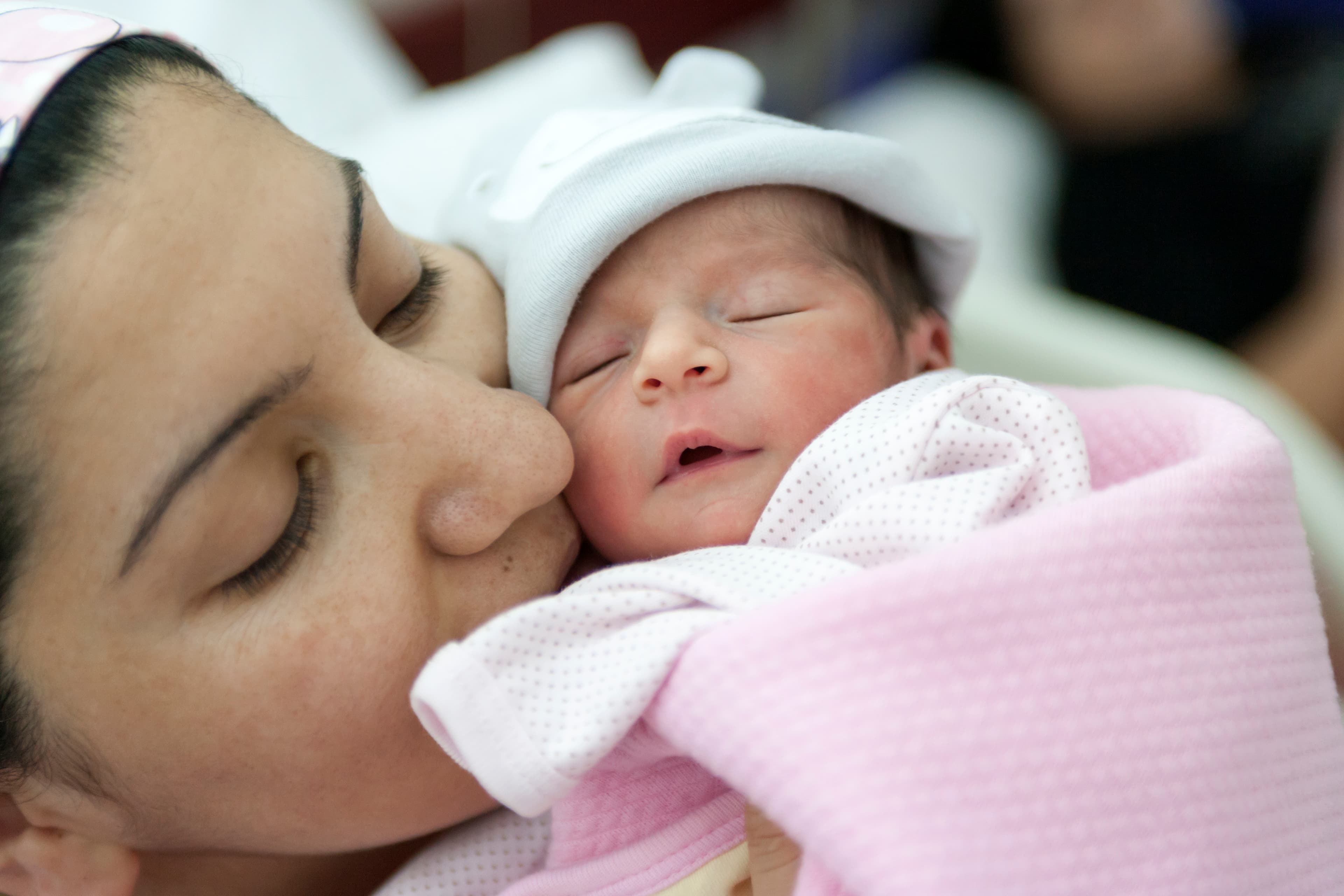 A newborn baby enters the world and mother holding newborn baby girl in the hospital.