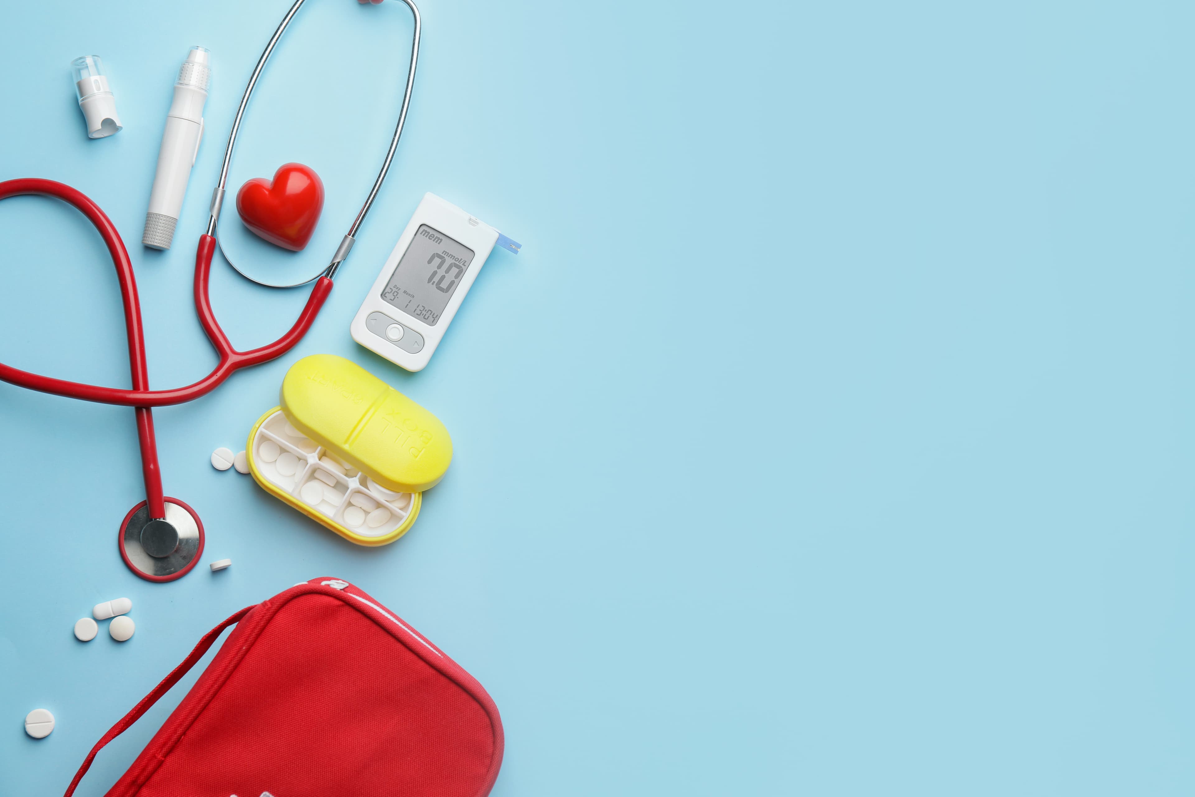 Glucometer with pills, stethoscope, lancet pen and heart on color background. Diabetes concept