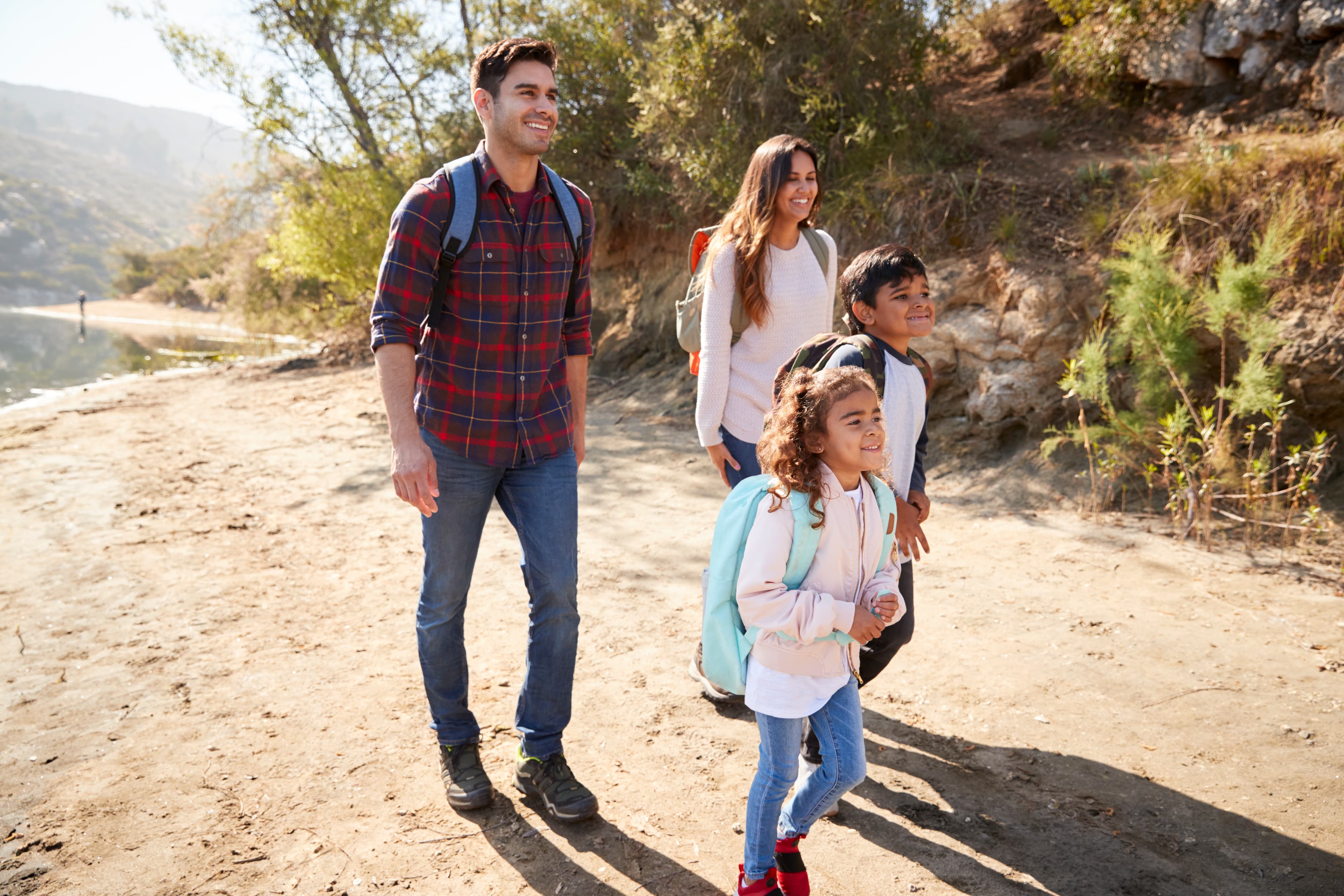 Parents and young children on a mountain hike in sunshine