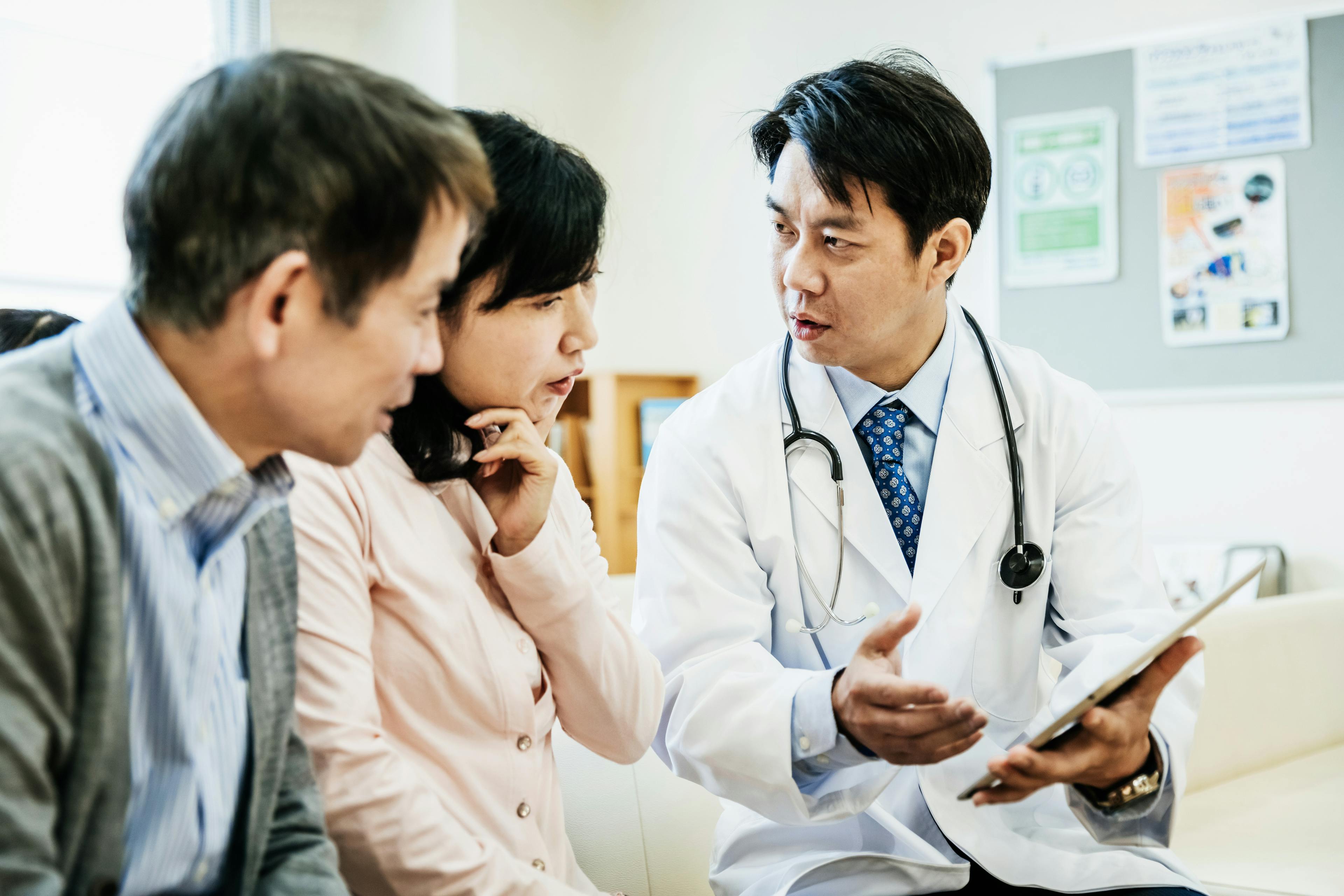 A doctor is explaining some test results to a couple in a Japanese hospital.
