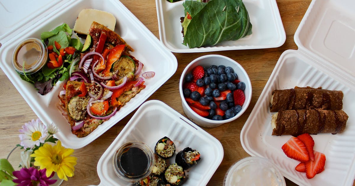 Takeout containers with vegetarian meals and desserts.