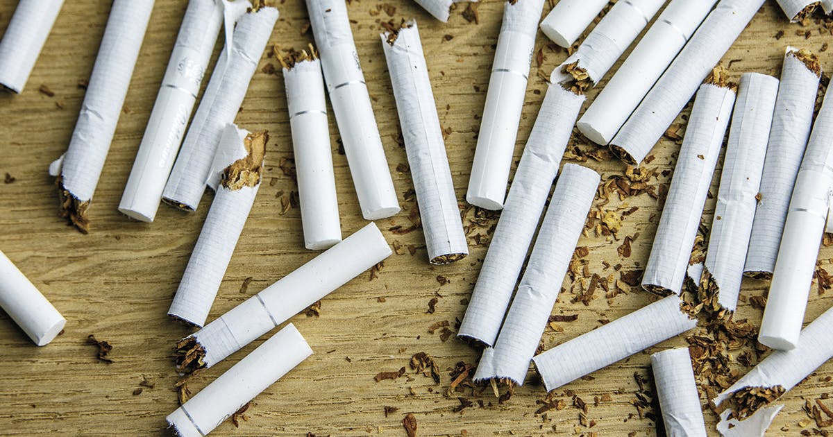 A pile of broken cigarettes on a table. 
