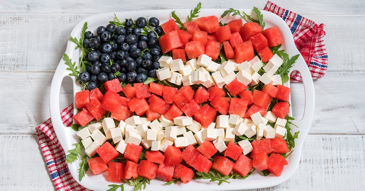 A platter of watermelon, cheese and blueberries arranged like an American flag.