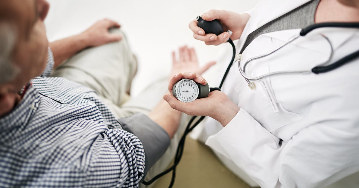 A medical professional takes a man’s blood pressure.