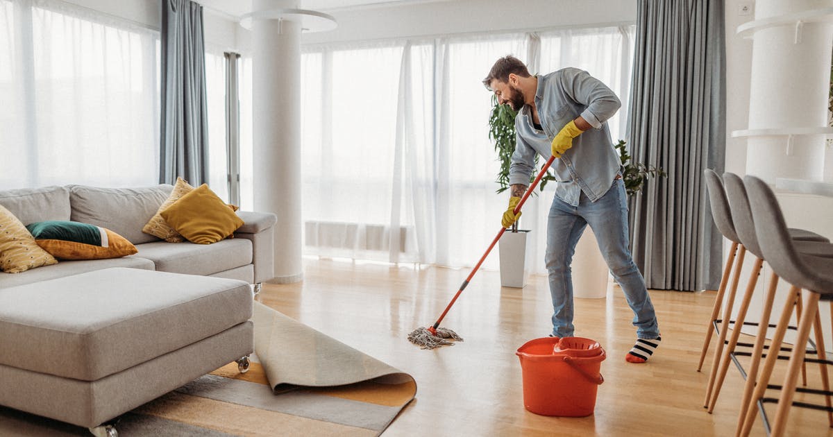 A man mopping a wood floor.