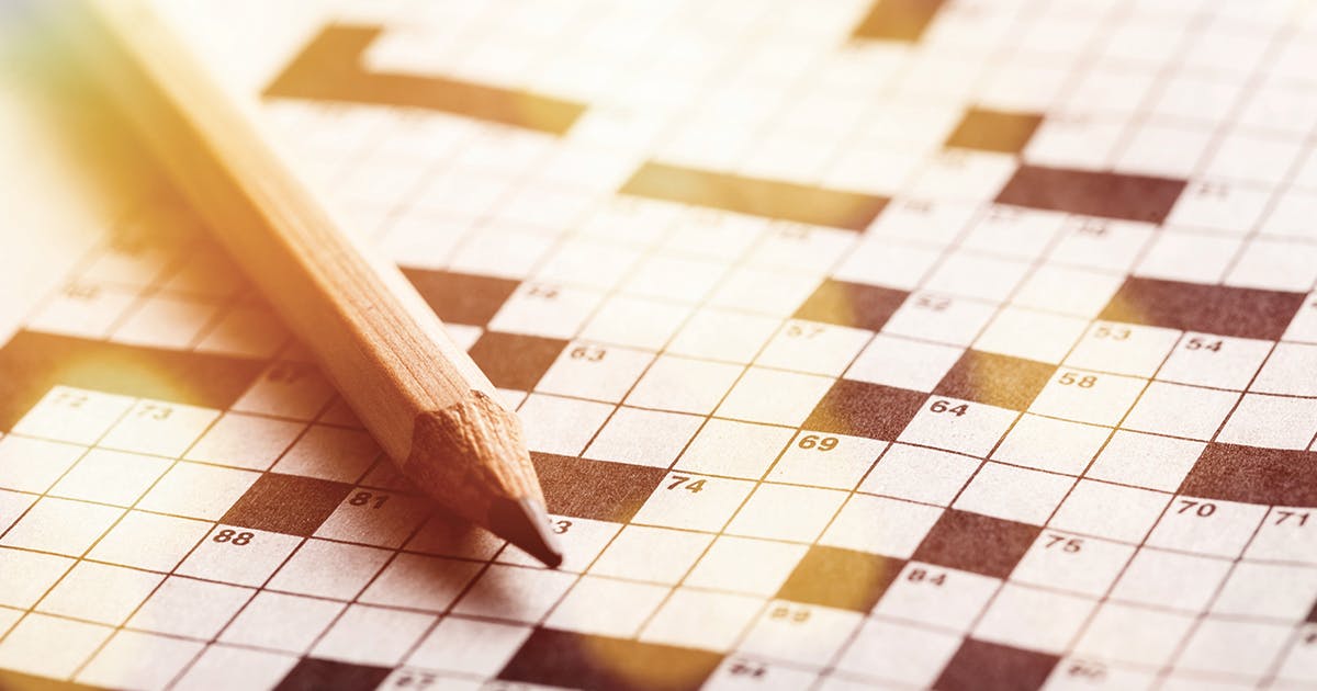 A pencil lying on a crossword puzzle.