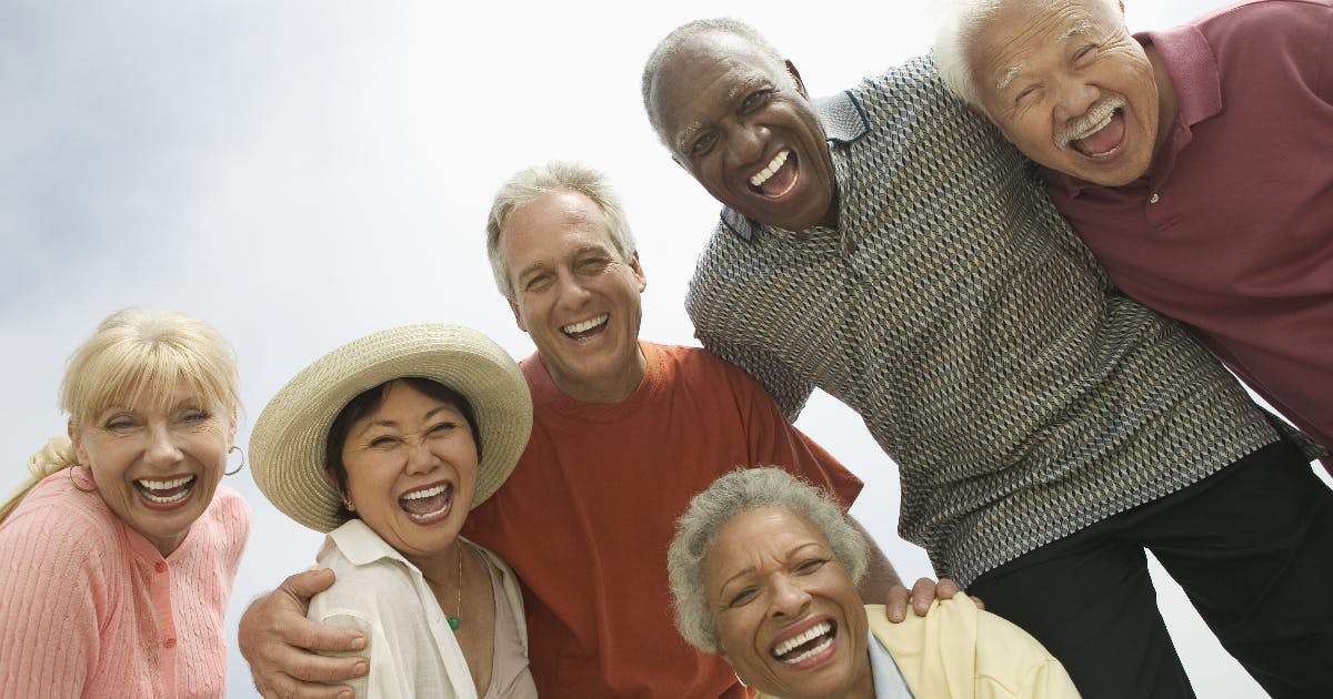 A group of older adults smiles down at the camera.