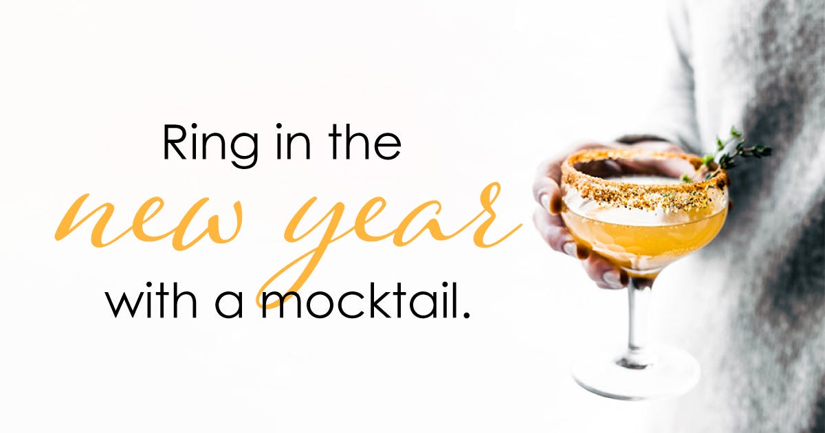 A person in a gray sweater holds an orange garnished beverage in a glass with a stem and a spiced rim. Text reads: Ring in the new year with a mocktail. 