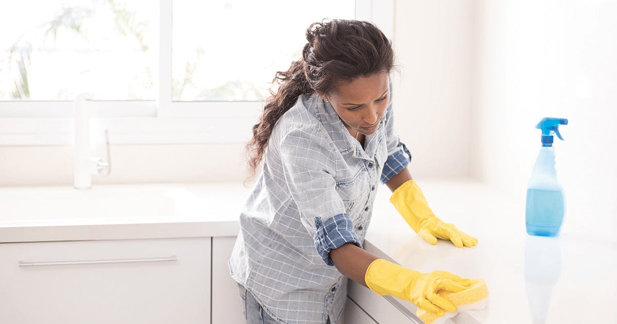 A woman cleaning her kitchen counters. 