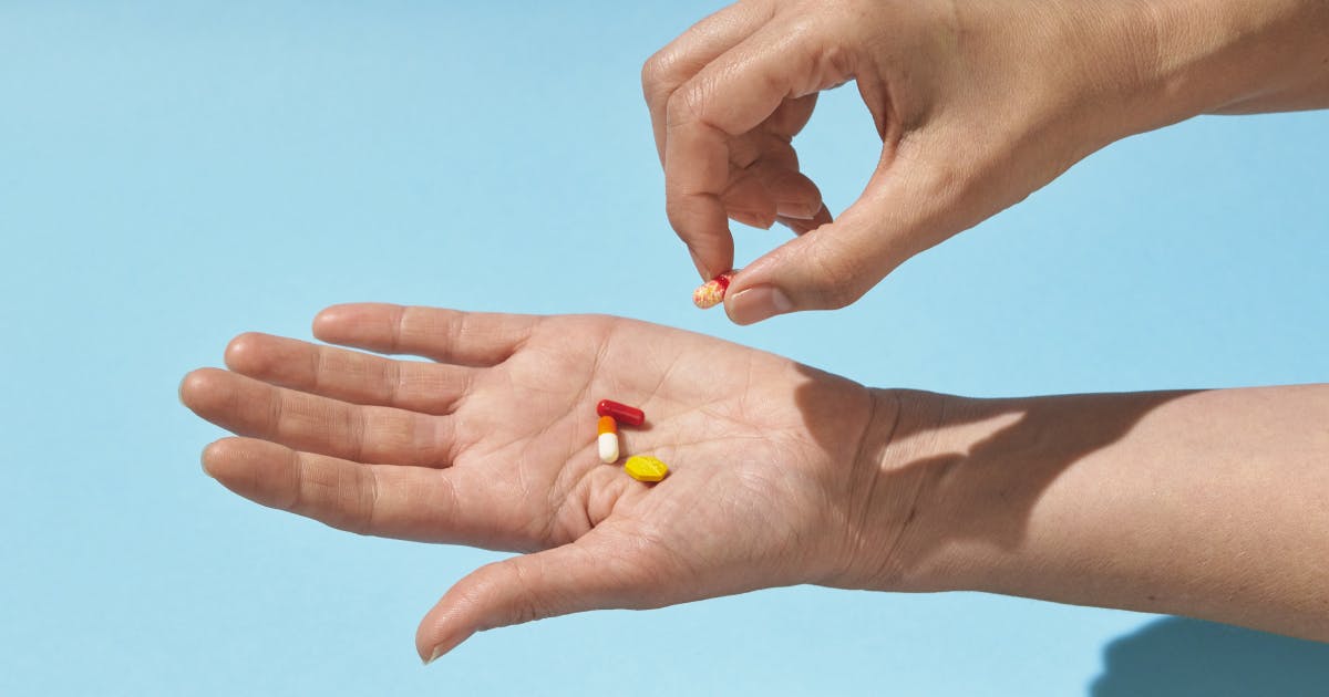 A person counts pills into their outstretched hand