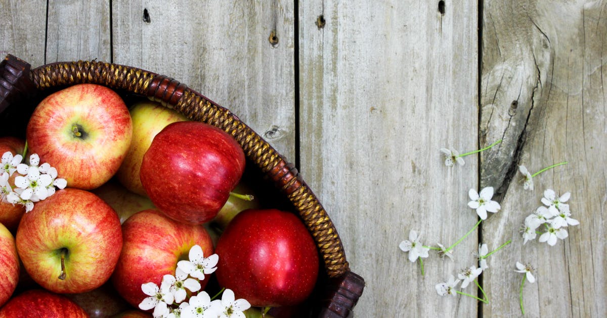 A basket of red apples and white flowers.