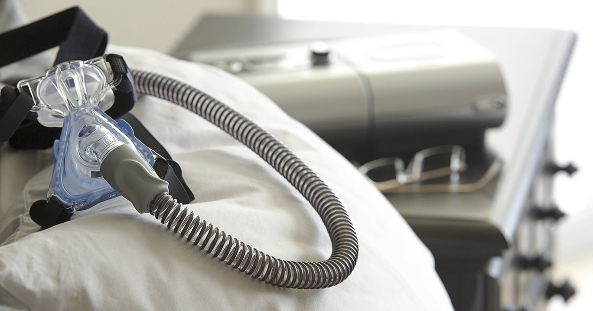 A CPAP machine for sleep apnea sitting on a bedside table.