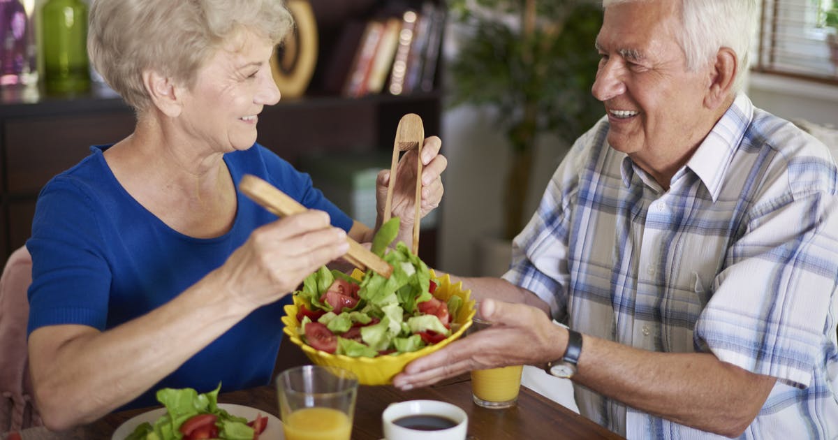 Senior couple eating salad.