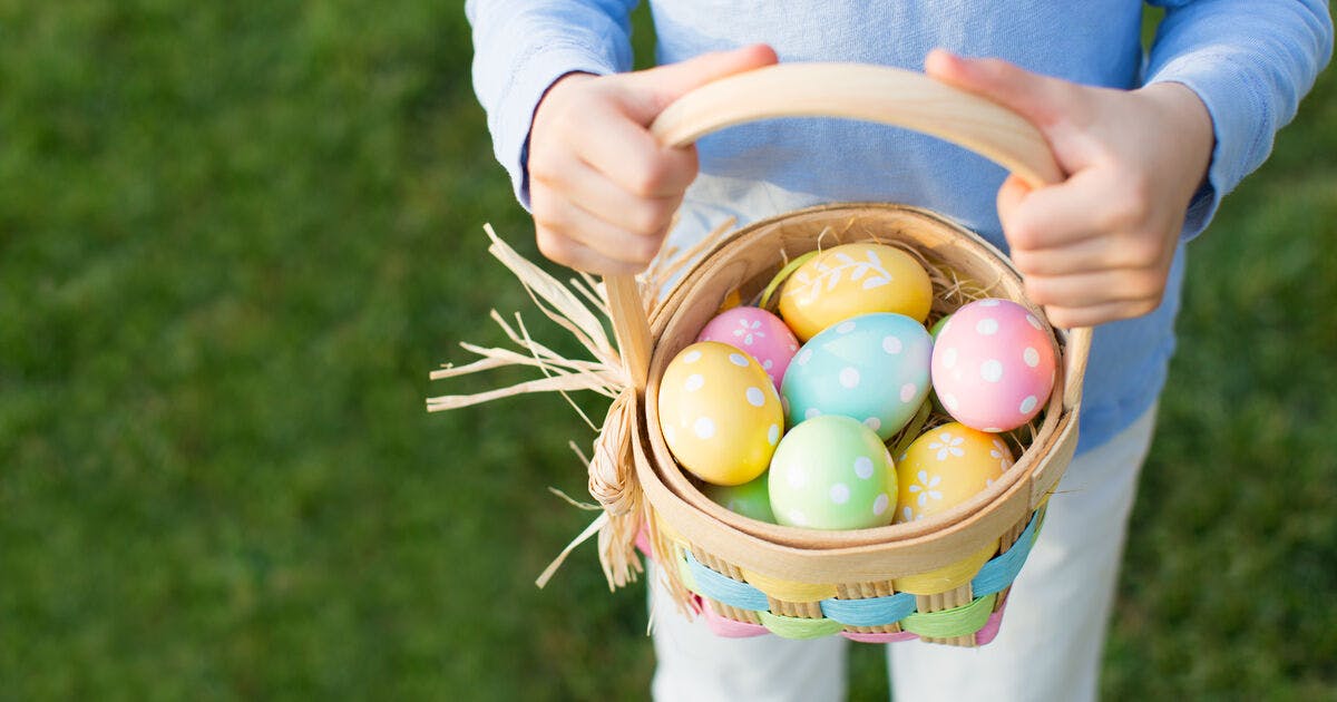 Photo of a child's hands holding an Easter egg basket.