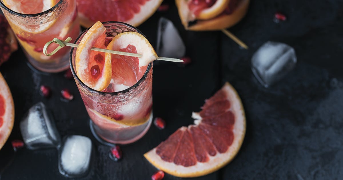 Glasses filled with ice, grapefruit and pomegranate seeds. 