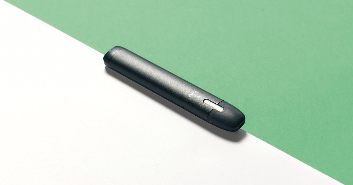 A vape pen sits on a table.
