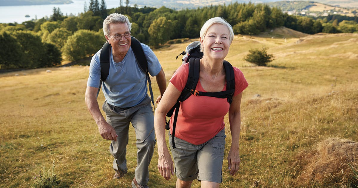An aging couple on a hike. 