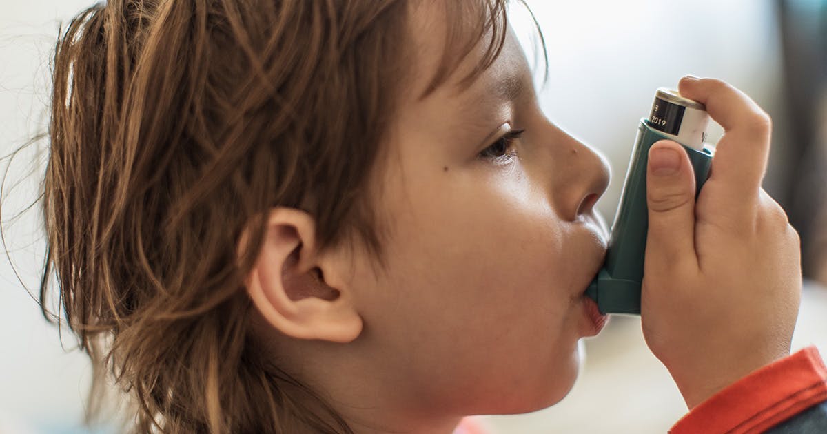 A young child using an inhaler. 