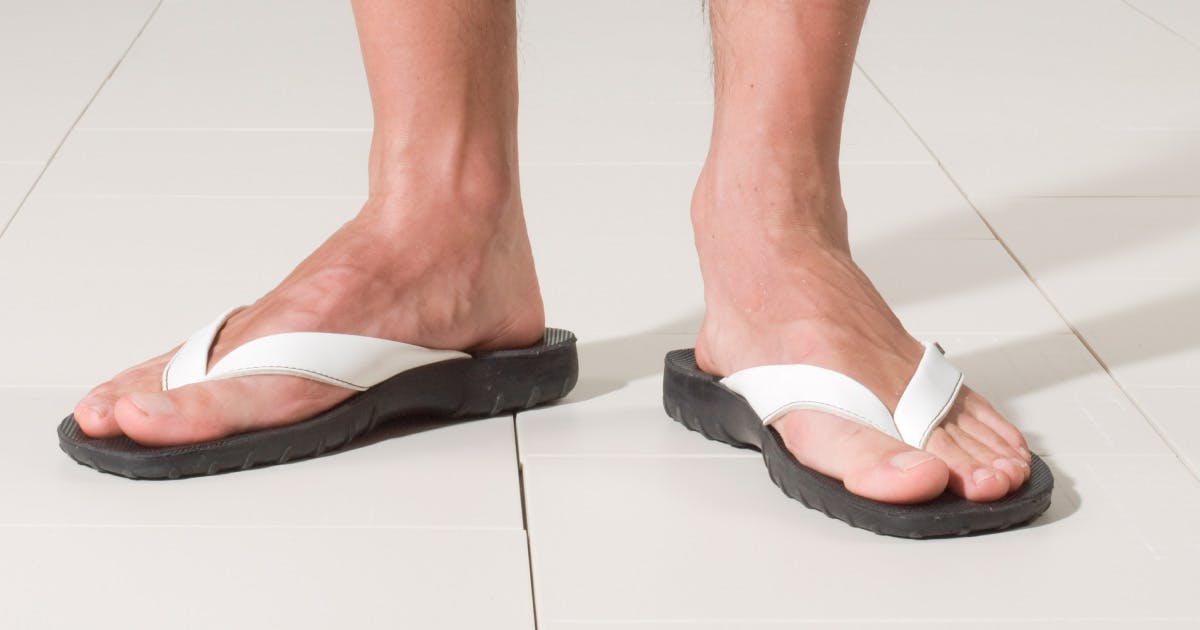 Feet wearing flipflops on a tile floor