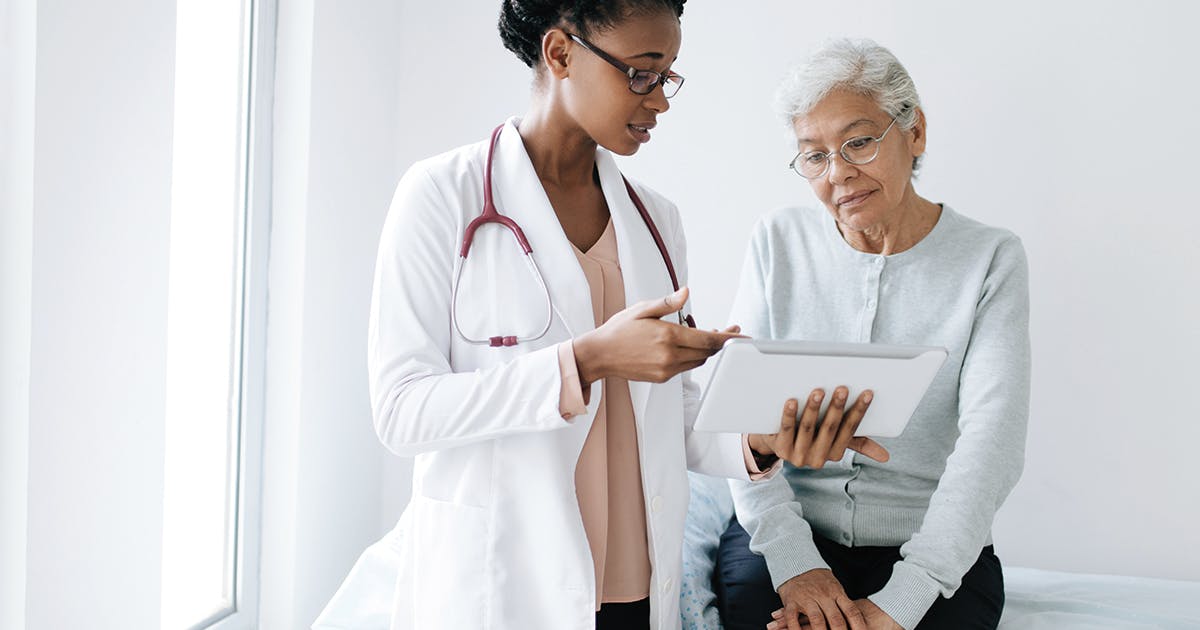 An elderly woman consults with her doctor. 