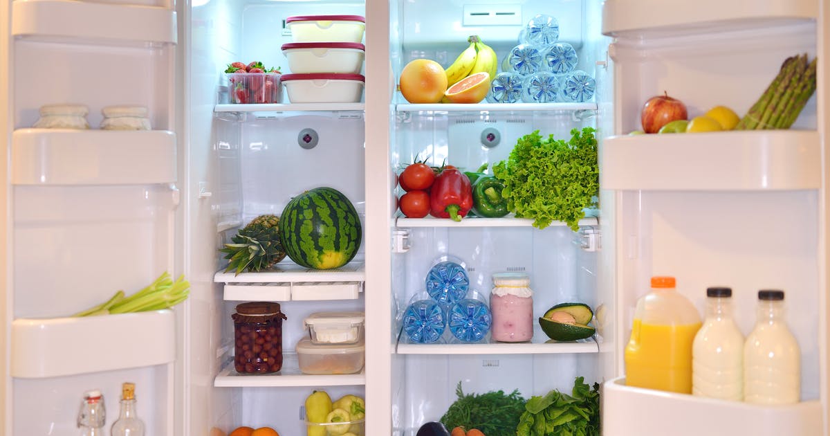 A wide-open fridge stocked with food and drinks.