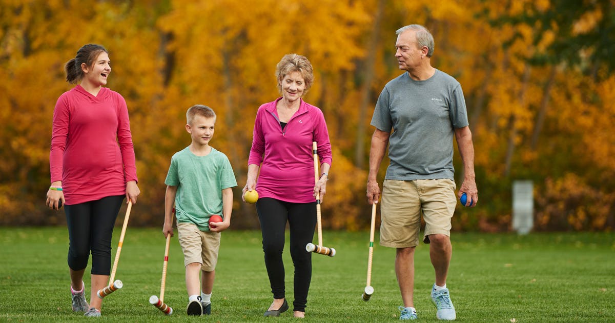  Grandparents and grandchildren walking with croquet mallets