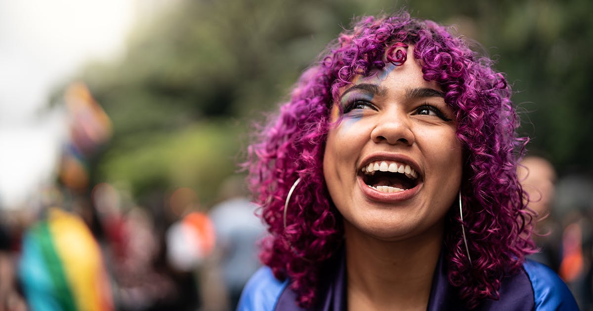 A smiling young woman with purple hair.