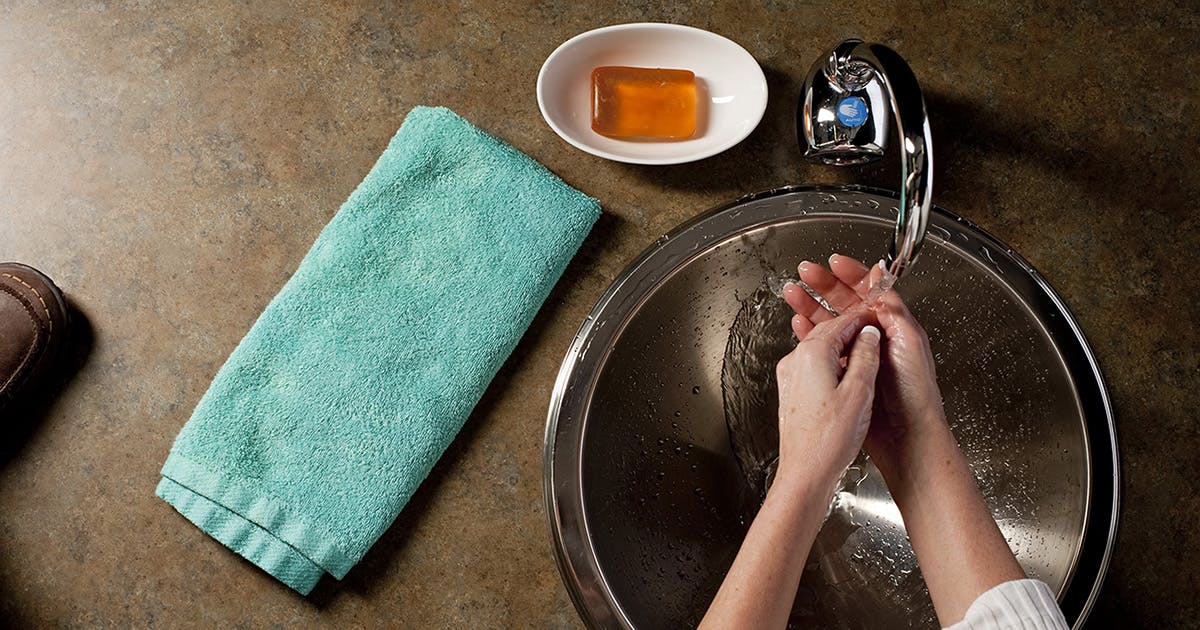 A closeup of hands washing in a sink.