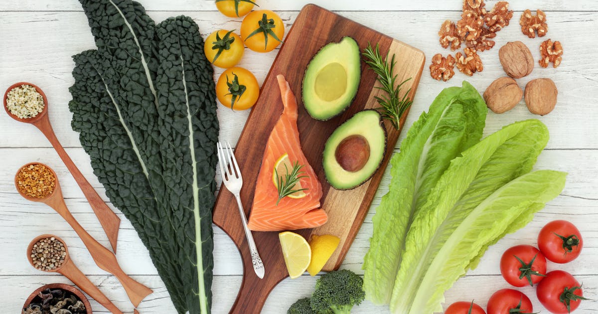 A spread of salmon, avocados, tomatoes, kale and other healthy foods.