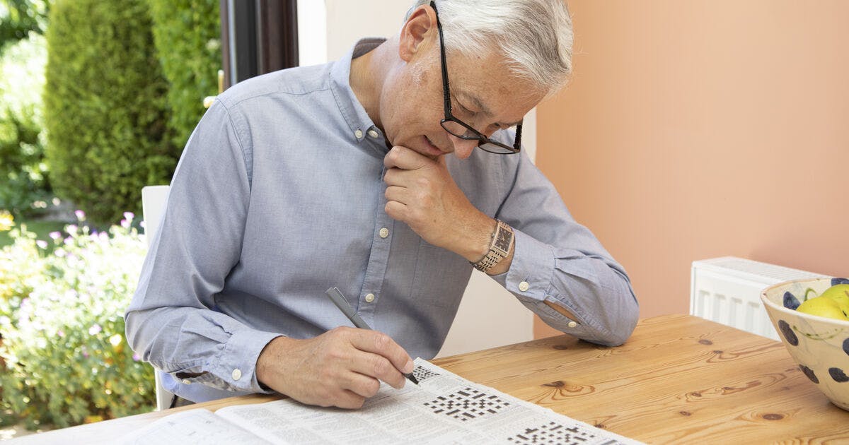 A man doing a crossword puzzle.